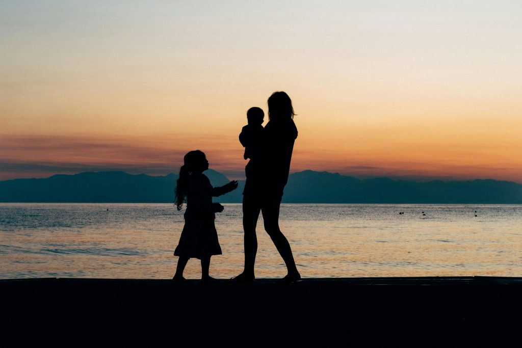 a mother and two children on the beach, the inner mother
